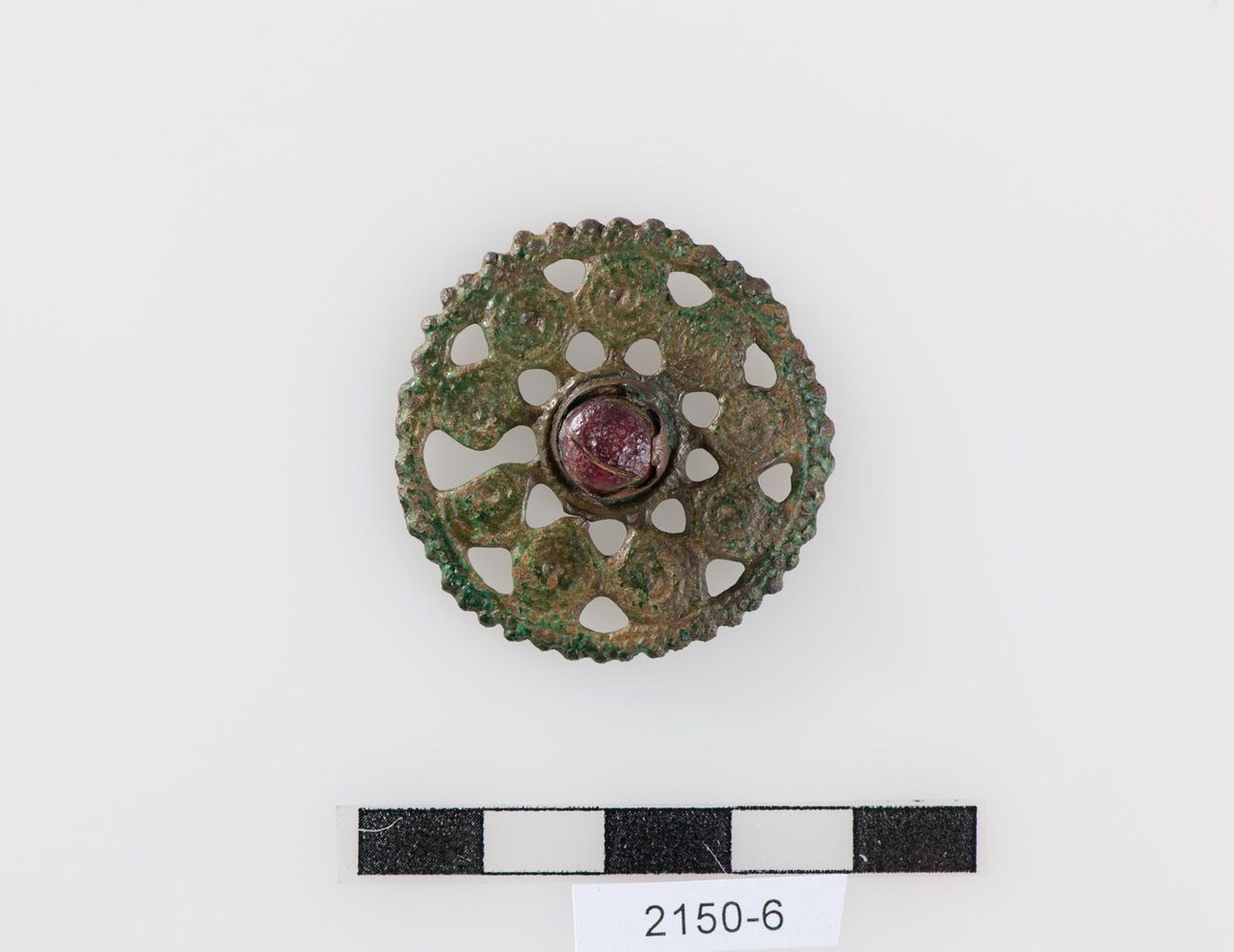 Bild 7: Scheibenfibel aus durchbrochenem Bronzeguss mit zentraler Glaseinlage. Fundort Morgarten ZG, 10. Jahrhundert n.Chr.