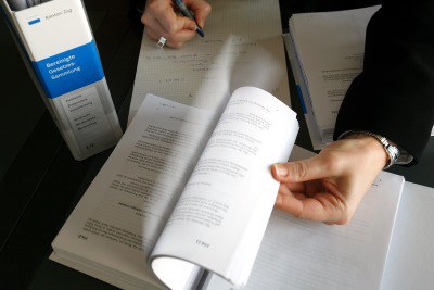 Frau nimmt Notizen aus einem offenen Gesetzesordner