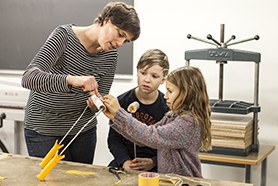 Lehrerin, Schüler und Schülerin bei der Arbeit
