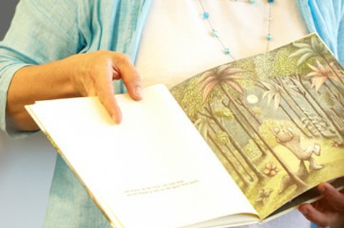 Person zeigt Buch beim Vorlesen