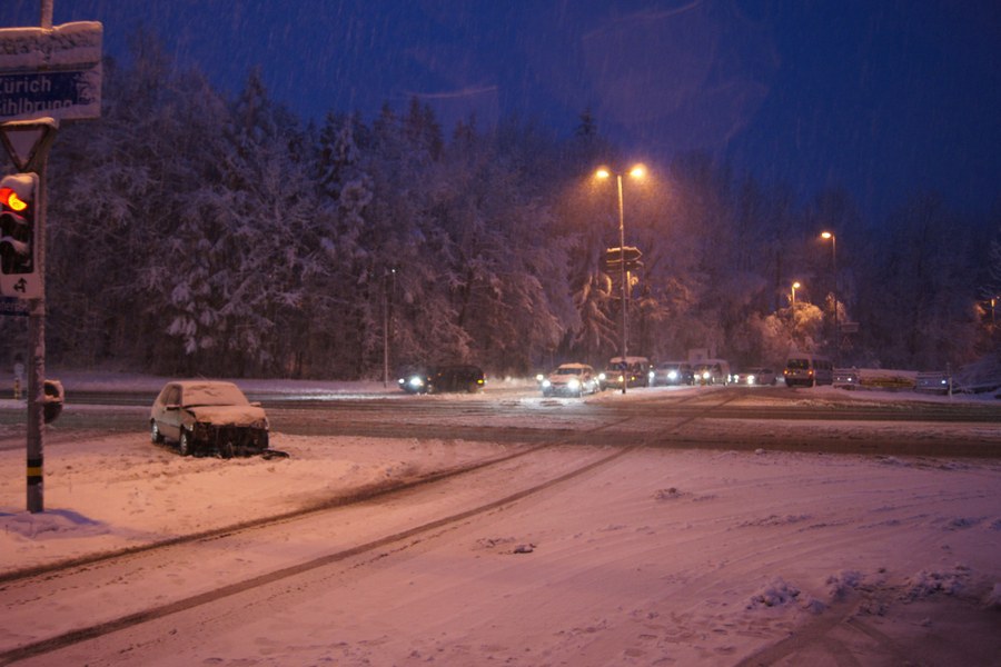 Verunfalltes Auto auf verschneiter Strasse